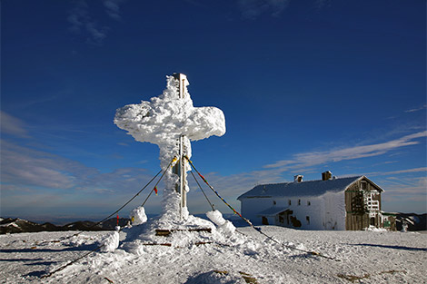Alois Günther Haus am Stuhleck und davor steht das komplett vereiste Gipfelkreuz